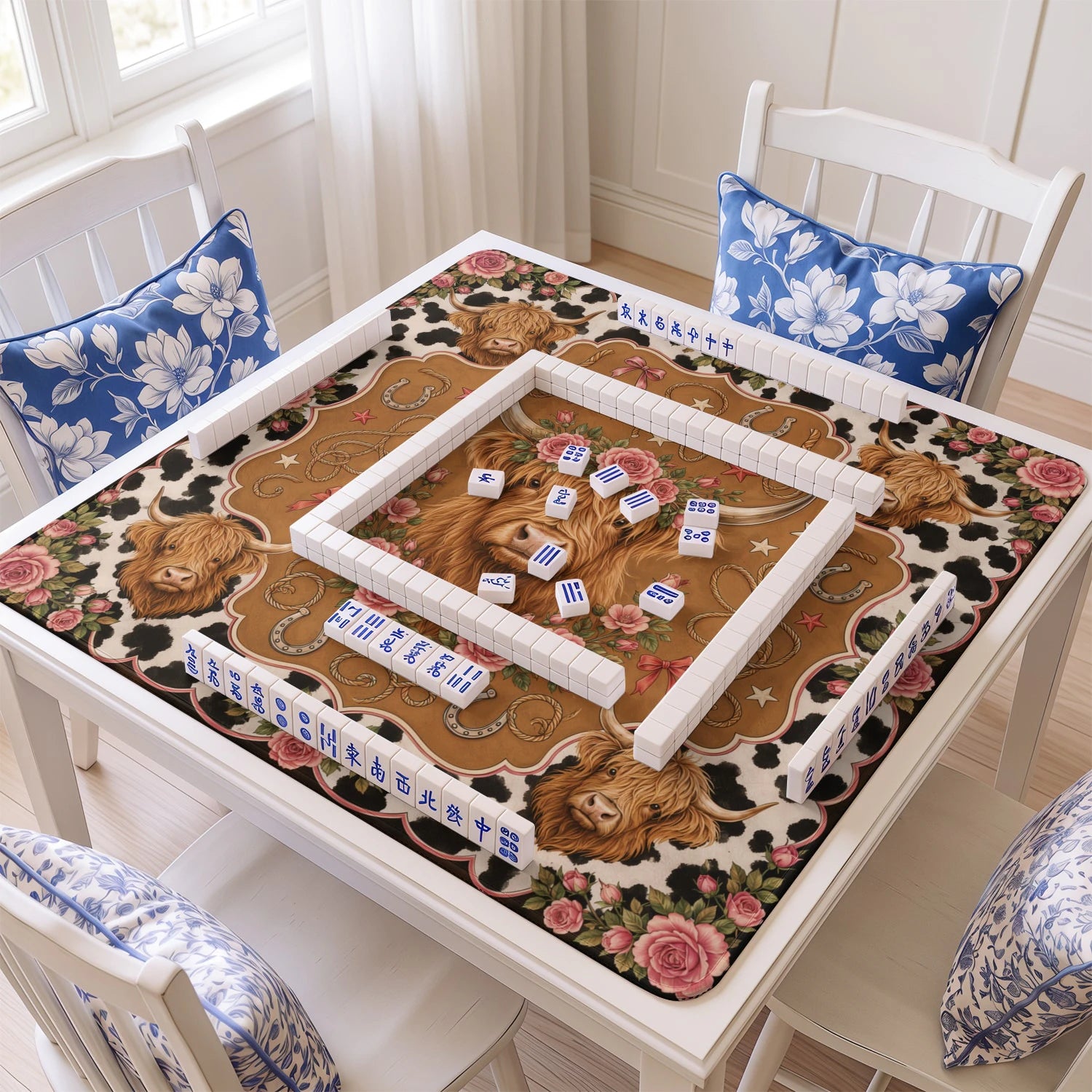 Highland Cow mahjong mat with tiles and racks on the table