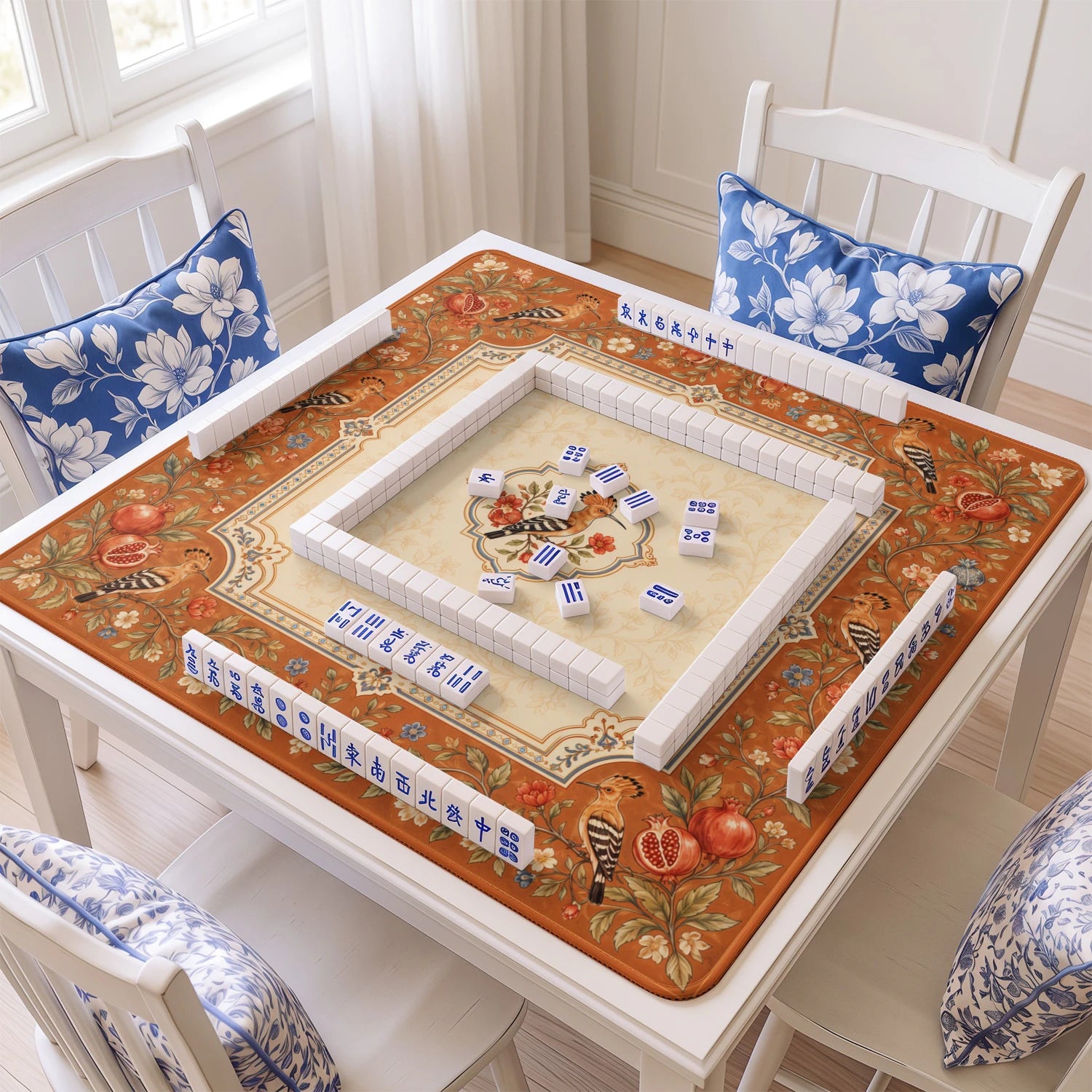 Hoopoe Pomegranate mahjong mat with tiles and racks on the table