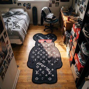 LV Bearbrick shaped area rug in a bedroom with sneakers and a skateboard