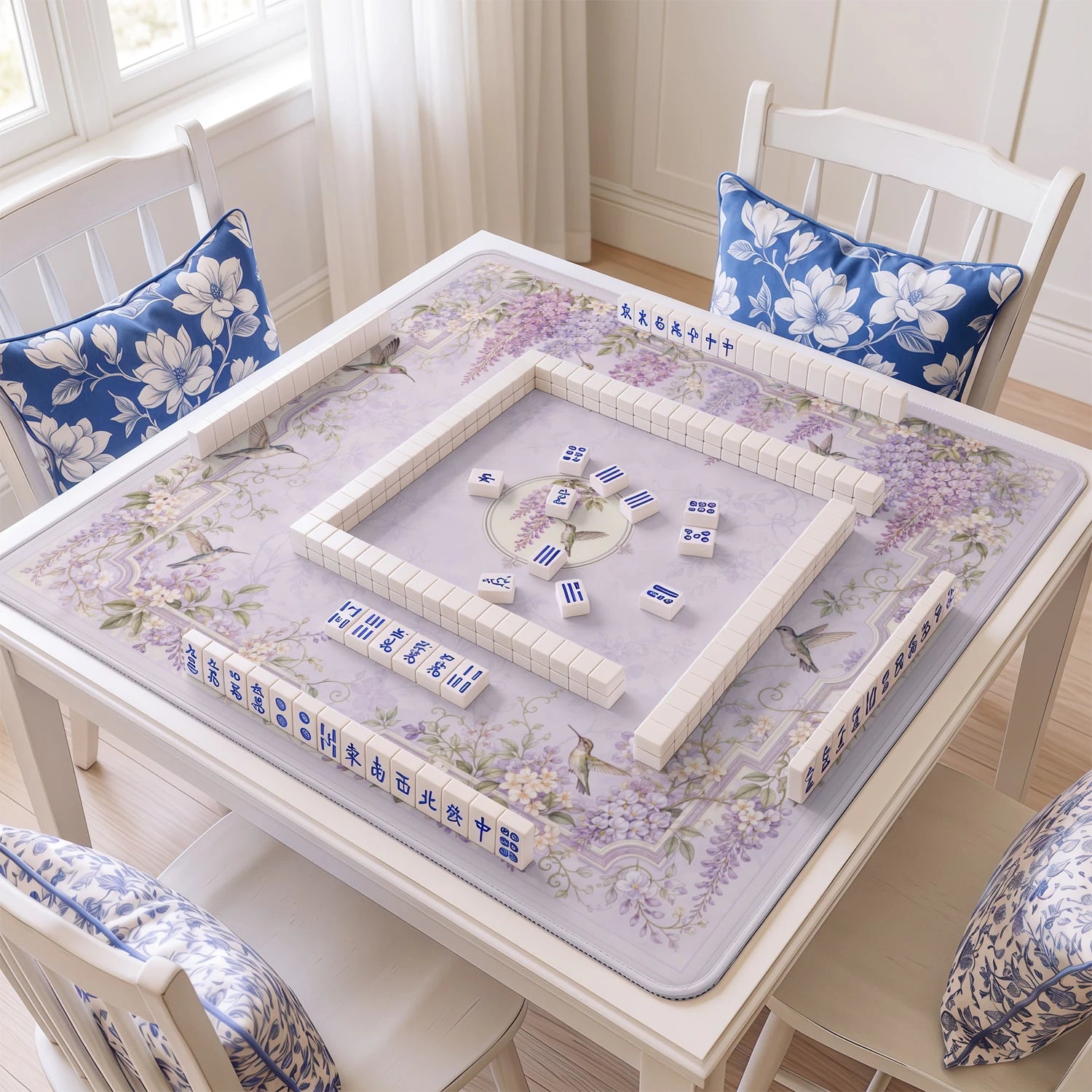 Wisteria Hummingbird mahjong mat with tiles and racks on the table